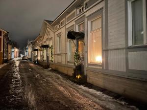a snowy street with a house with a christmas tree on it at Cozzy apartment in old Rauma in Rauma
