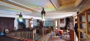a living room with two chandeliers hanging from the ceiling at Auberge des peupliers Café Restaurant in Akhendachou nʼAït Ouffi