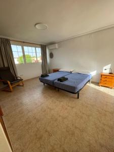 um quarto com uma cama e uma cadeira em Bungalow familiar con piscina em San Juan de Alicante