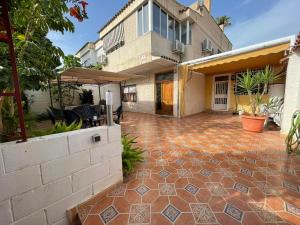 uma imagem de uma casa com um pátio de tijolos em Bungalow familiar con piscina em San Juan de Alicante