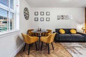 een eetkamer met een tafel en stoelen en een bank bij Parkside 2 bedroom house near Dunfermline & Edinburgh in Dunfermline