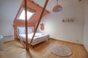 ein Schlafzimmer mit einem Bett und einem großen Fenster in der Unterkunft Le Loft - Triplex 200m2 en centre-ville in Épernay