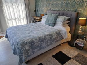 sypialnia z dużym łóżkiem z niebieską kołdrą w obiekcie Sunbrae Beach Sanctuary free high Fibre wifi w mieście Mount Maunganui