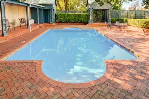 una gran piscina en un patio con un patio de ladrillo en Steele Cottage en Vicksburg