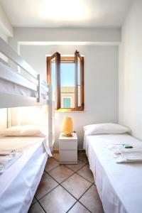 two beds in a room with a mirror at Villa Aura in Marina di Modica