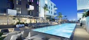 uma piscina com espreguiçadeiras e um edifício em Cozy Apartment in the Heart of LA em Los Angeles