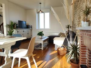 a living room with a couch and a table at Maison wifi jardin arboré pointe du Raz in Plogoff