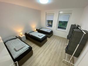 a small room with two beds and a couch at City Apartment - 9 Bedrooms - 22 Beds - WiFi - Kitchen in Paderborn
