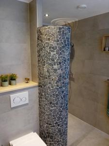 een badkamer met een douche en een stenen muur bij Oudaen 36 in Lelystad