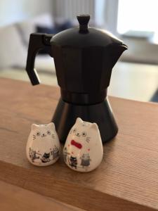 a black coffee pot with two hello kitty cookies at Downtown Apartment Murano in Warsaw