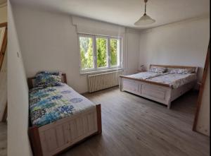 SzóládにあるGroßes Ferienhaus Plattensee Balaton - nyaraló ház 6 szobával, 5 fürdőszobával, 3000 nmのベッドルーム1室(ベッド2台、窓付)