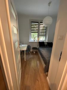 a room with a bed and a table and a window at Downtown Apartment Murano in Warsaw