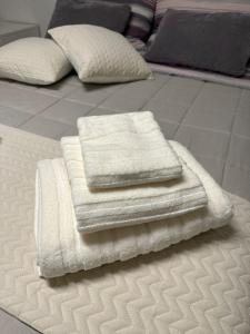 una pila de toallas blancas sentadas encima de una cama en Appartamento Su Planu IUN R5007, en Pirri