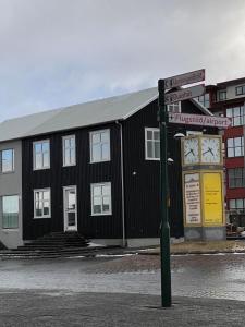 Un edificio negro con un reloj a un lado. en Ray of Sunshine Hafnargata, en Keflavík