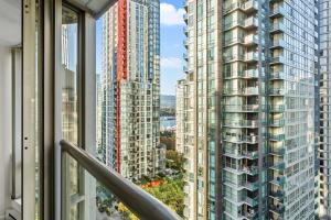 a view from a balcony of two tall buildings at Downtown Luxury 1BR Coal Harbour in Vancouver