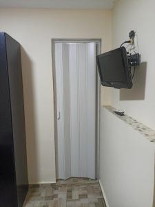 a door to a room with a tv on a wall at Hostel Morais in Maceió