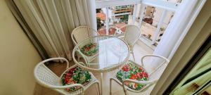 a table and chairs on a balcony with flowers at Top Wave Itapoã 2 (702s) in Vila Velha