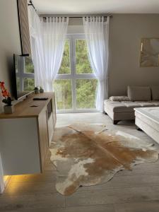 a living room with a large window and a couch at Apartmani Berg in Pale