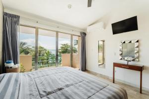 a bedroom with a large bed and a large window at Seáak Cancun Rentals in Cancún +55 photos