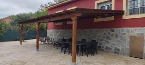 a patio with a table and chairs under a roof at Casa Ambite in Ambite