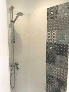 y baño con ducha y pared de azulejos. en maison de vacances en bord de mer, en Saint-Hilaire-de-Riez