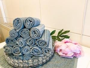 une pile de serviettes dans un bol à côté d'une fleur dans l'établissement Citynah, Balkon, große Küche und Garten, à Hanovre 33 autres photos