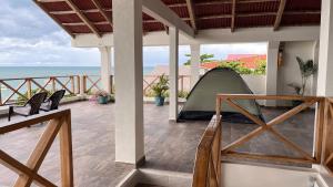 a tent on a porch with the ocean in the background at Merakai Hostel Rincon del Mar in Rincón +61 photos