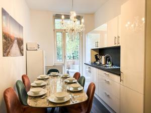 une salle à manger avec une table et des chaises et une cuisine dans l'établissement Citynah, Balkon, große Küche und Garten, à Hanovre