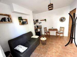 a living room with a black couch and a table at La Tejita Studio in La Tejita