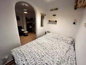 a bedroom with a bed with a black and white comforter at La Tejita Studio in La Tejita