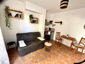 a living room with a black couch and a table at La Tejita Studio in La Tejita