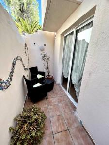 a balcony with a black chair and a window at La Tejita Studio in La Tejita