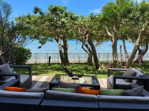un soggiorno con divano e vista sulla spiaggia di Michelle’s flat by the Sea a Noumea