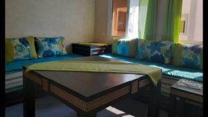 een woonkamer met een bank en een tafel bij Appartement Anis in Agadir