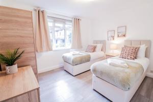 1 dormitorio con 2 camas y ventana en 2 Bed Apartment - Great Location, en Hendon