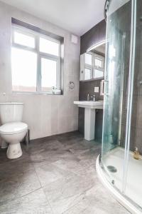uma casa de banho com um WC, um chuveiro e um lavatório. em 2 Bed Apartment - Great Location em Hendon
