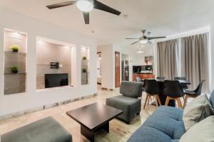 a living room with a couch and chairs and a table at Seáak Cancun Rentals in Cancún