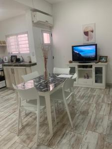 uma sala de jantar com uma mesa e cadeiras e uma televisão em AQUI ES!!! em Banfield