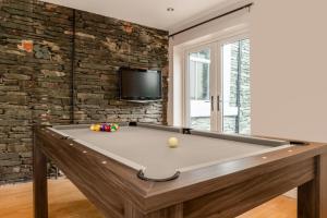 a pool table in a room with a tv at The Tall House - Sleeps 16 in Keswick