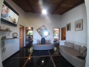 a living room with a couch and a mirror on the wall at Casa Namaste del Pacifico - Luxury Villa in Santa Teresa Beach