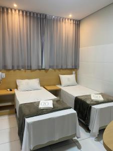 Cette chambre comprend 2 lits et une fenêtre. dans l'établissement Hotel New House, à São Paulo