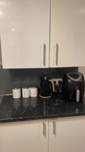 a black counter top with a tea kettle and cups at RAHAL OUTRAM in London
