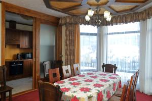 a dining room with a table and a large window at Shale Anemona in Bukovel