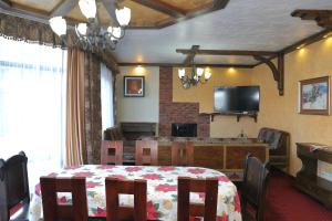 a dining room with a table and a television at Shale Anemona in Bukovel