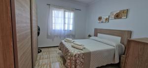 a small bedroom with a bed and a window at Altillo Vista Mar in Moya