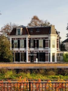 una casa grande sentada al lado de una carretera en Villa Benvenuto en Dieren