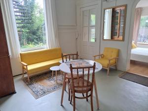 - un salon avec une table, des chaises et un canapé dans l'établissement Villa Benvenuto, à Dieren