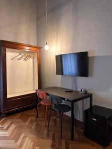 a room with a desk with two chairs and a television at Botta 9 in Bergamo