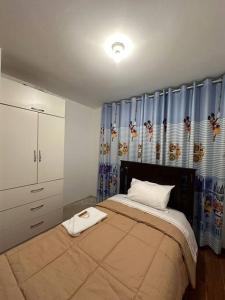 um quarto com uma cama grande e cortinas azuis em Casa San Andrés Arenas I em Pisco