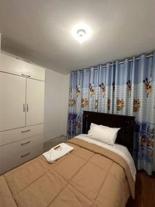 1 dormitorio con 1 cama grande y cortinas azules en Casa San Andrés Arenas I, en Pisco